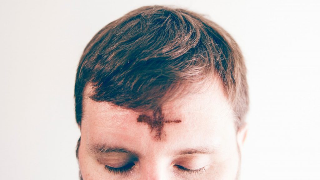 Man with ash cross on her head