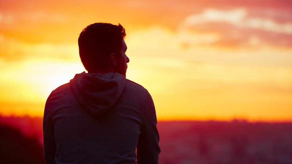 Man looking at sea during sunset