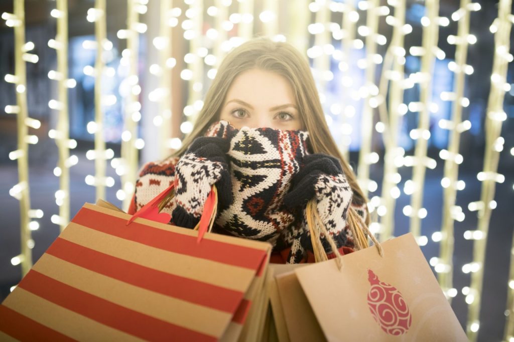 girl with scarf holding Christmas shopping bags