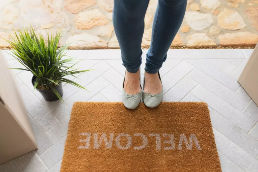 a woman's feet next to a welcome mat - she's waiting to meet her boyfriend's family