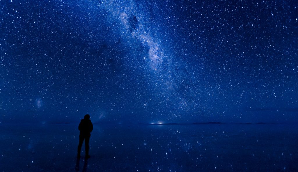 silhouette of person against blue starry sky