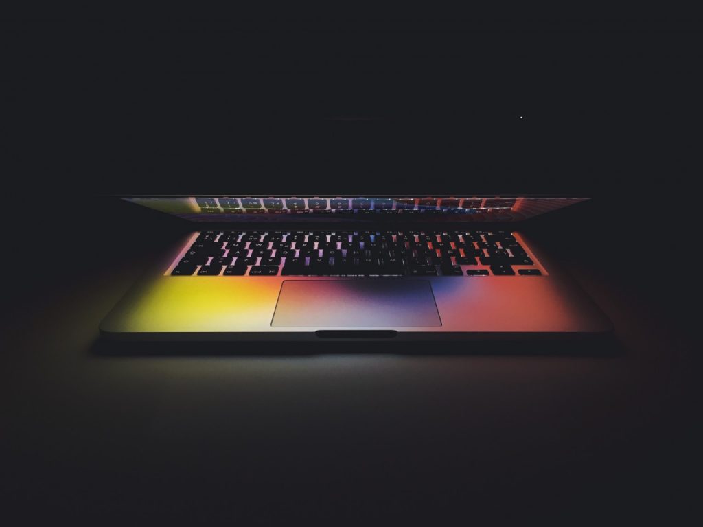 Half-closed laptop with dark background
