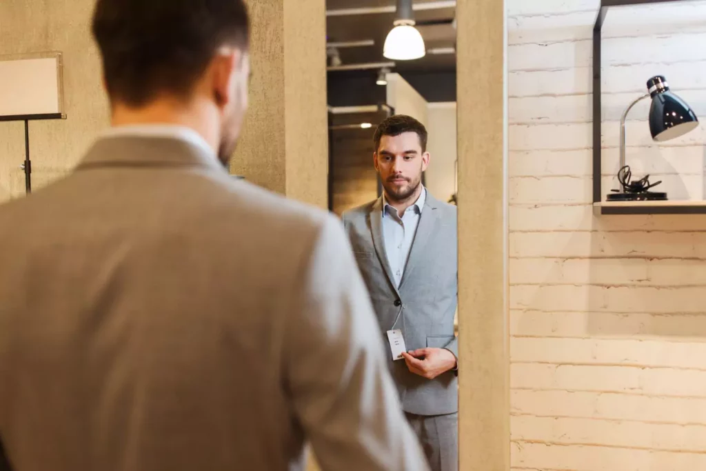 man looking in a mirror trying on a new suit