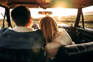 a man and a woman sitting in a car looking at the sunset talking about physical boundaries