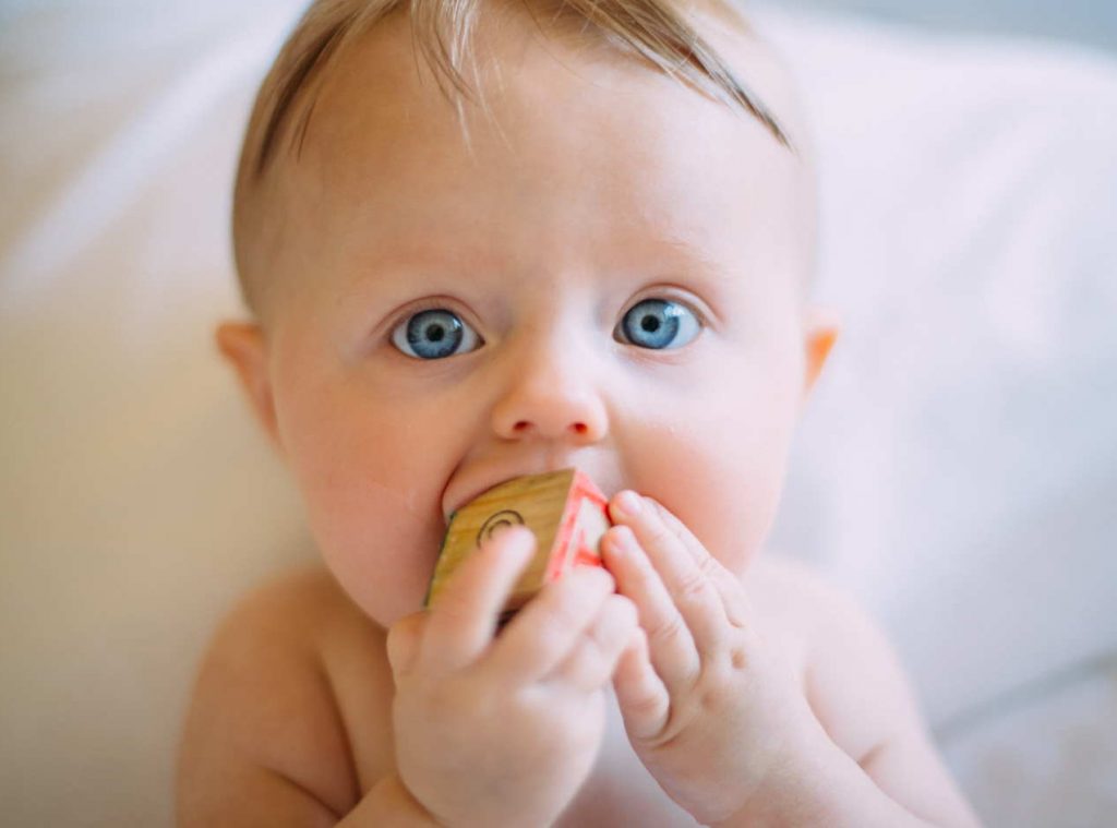 baby chewing on a block