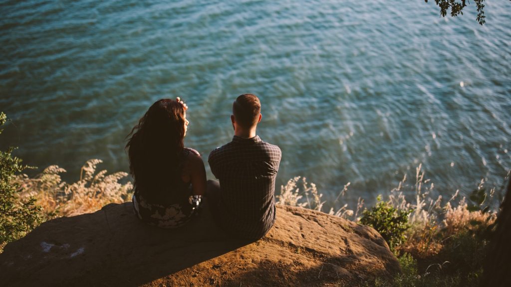 couple sitting by lake