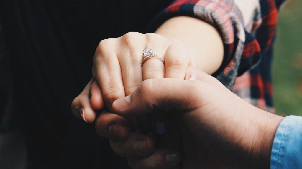 couple's hands and engagement ring