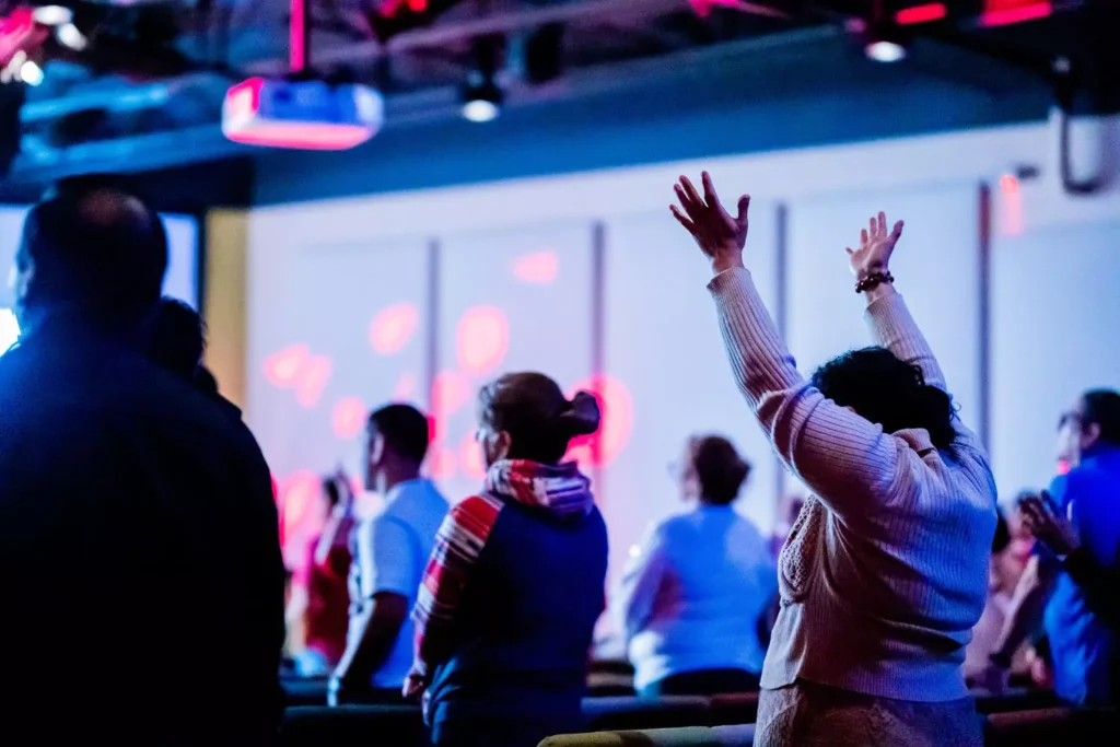 a woman worshipping at a conference. What does biblical worship look like?