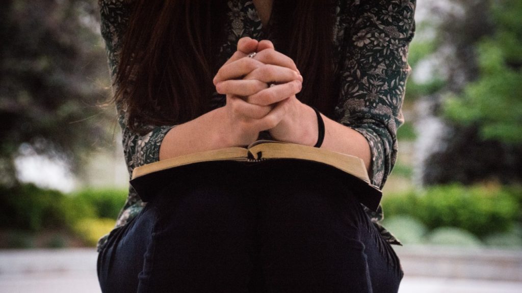 woman with bible praying
