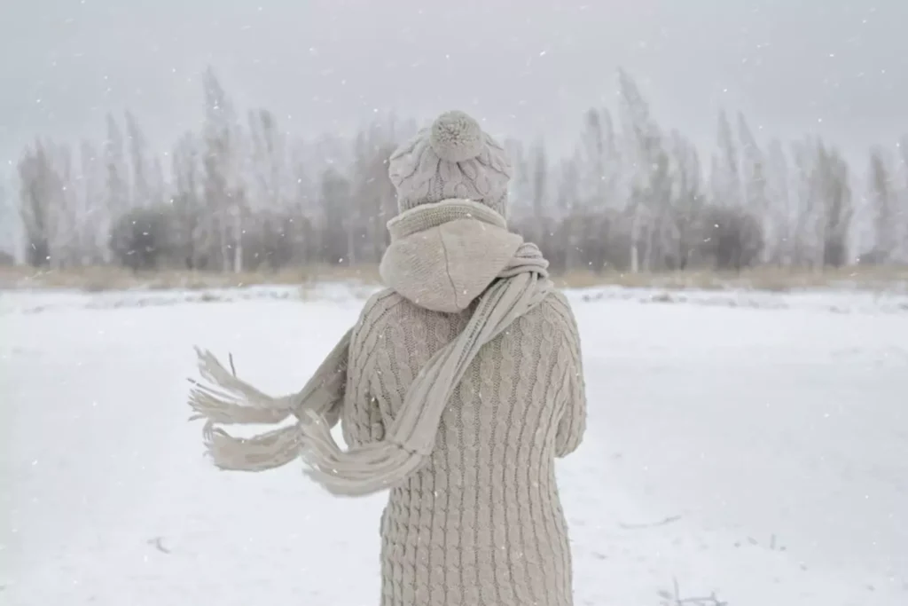 a woman standing alone in the snow