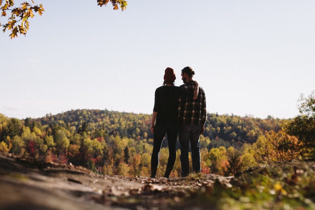 couple standing over fall forest