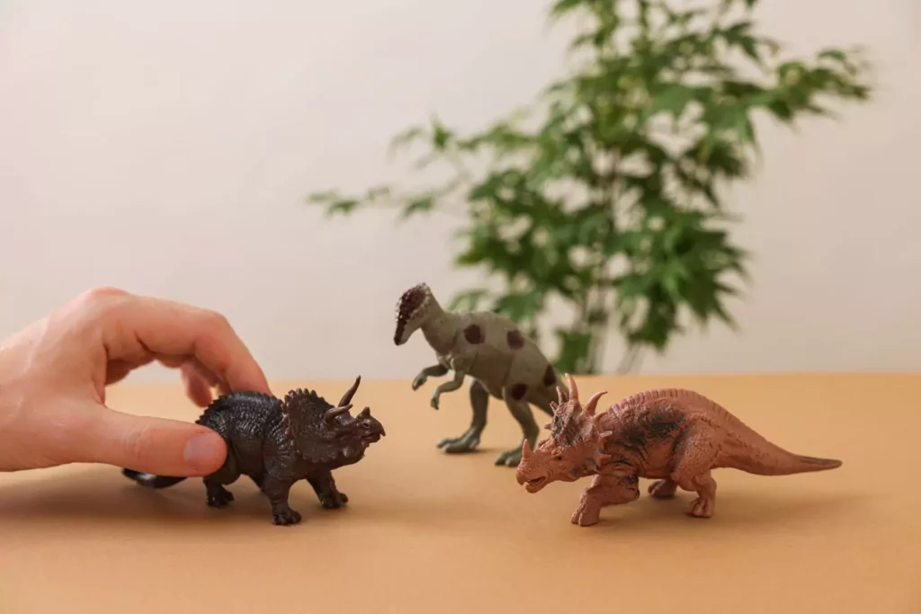 someone playing with toy dinosaurs