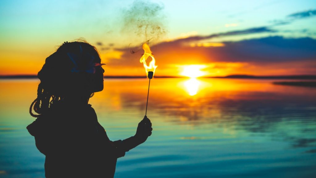 woman on beach with flame