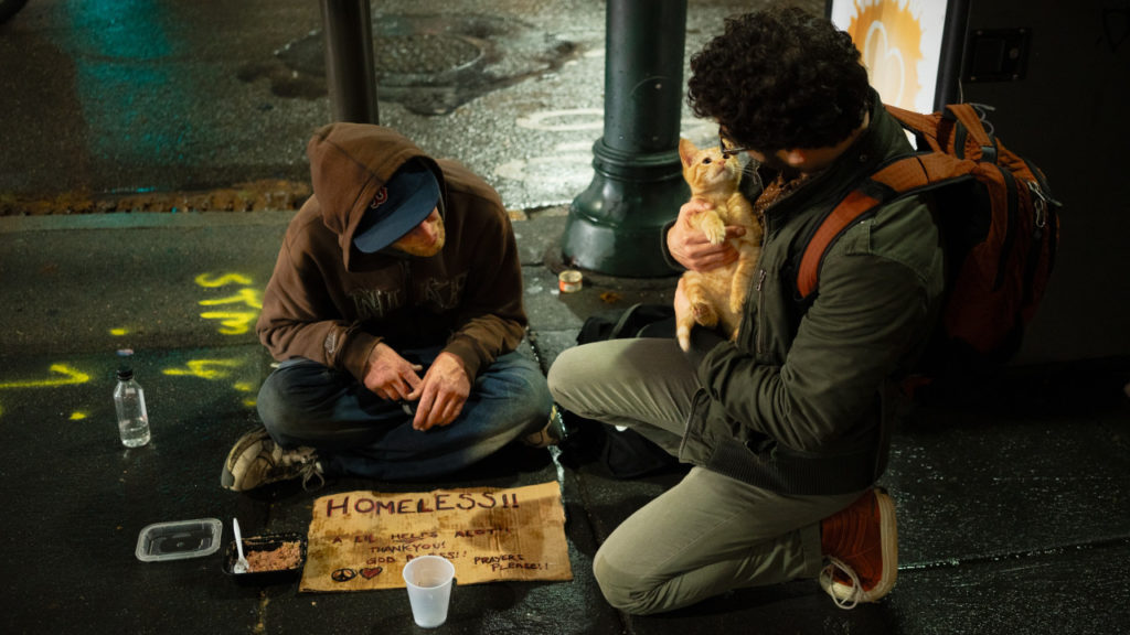 man with homeless man and cat