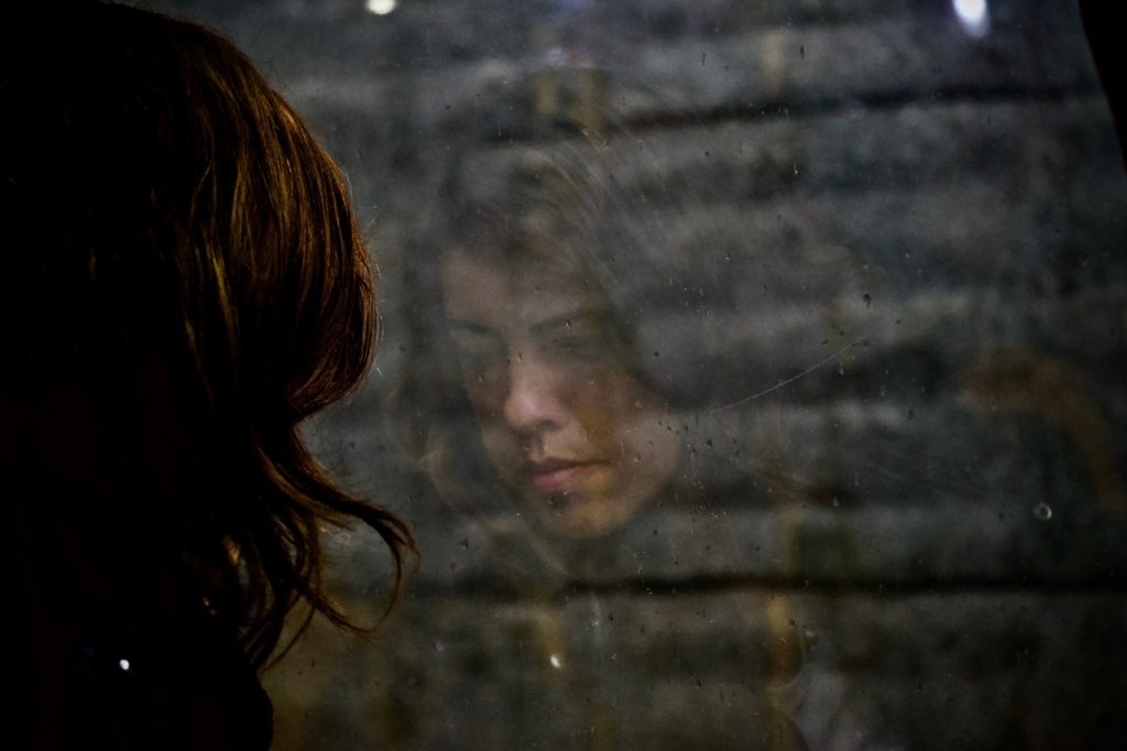Reflection in window of a sad woman