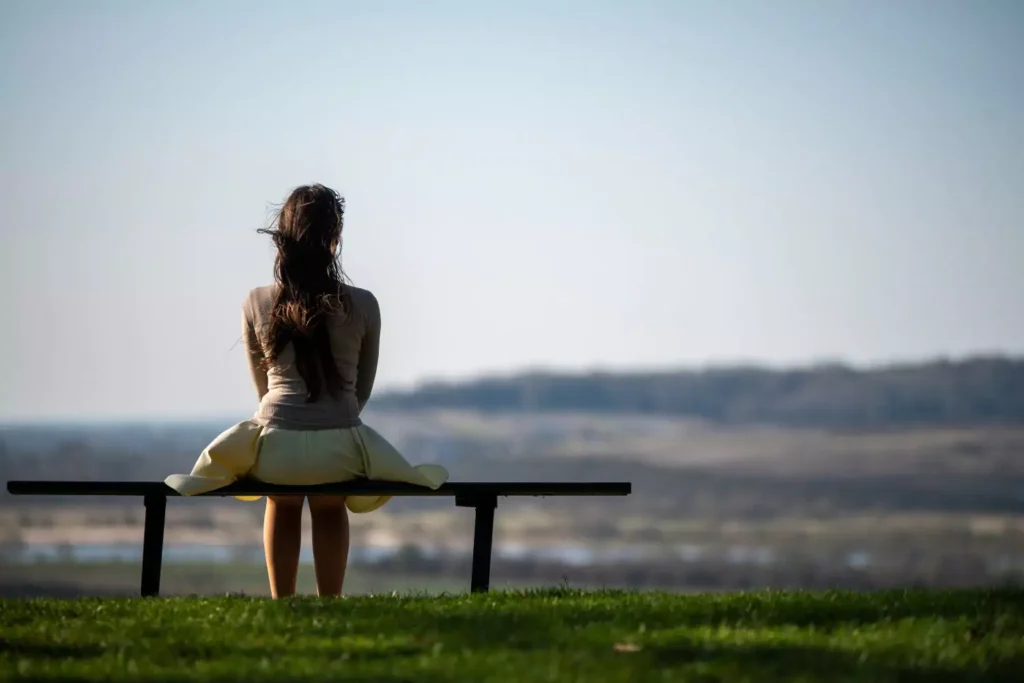 a woman sitting alone on a bench on mother's day