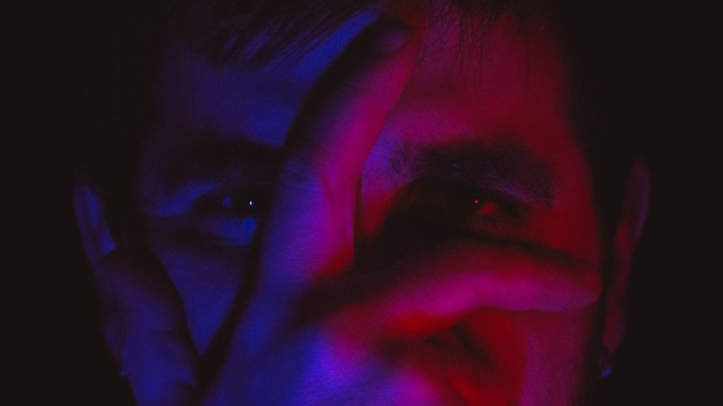 blue and red light on mans face