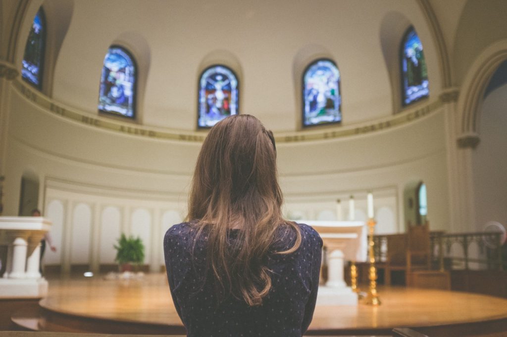 Woman standing in front of sanctuary facing altar