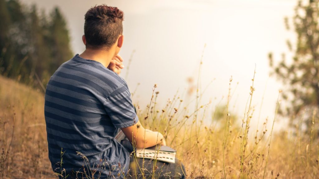 man with bible by lake