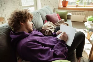 a man laying on a couch living an average life