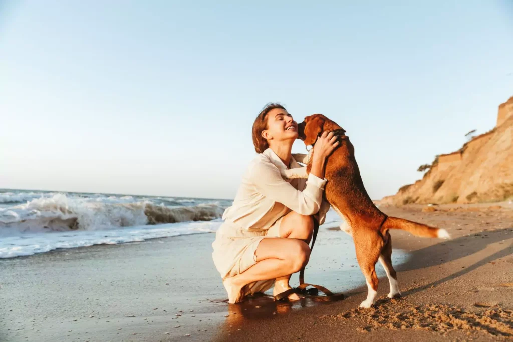 Think about her adult formation, a young woman on the beach isgetting "kisses" from a dog