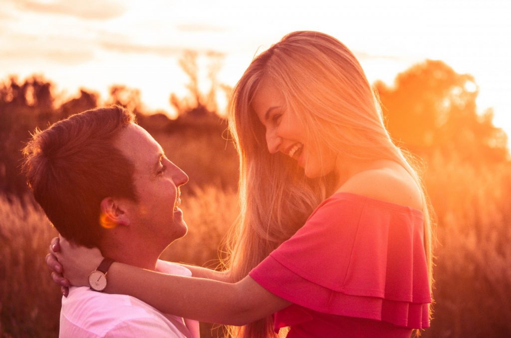 couple smiling at each other outside during golden hour