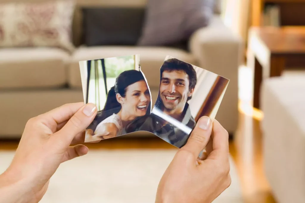a person ripping a picture of a couple in half - divorce