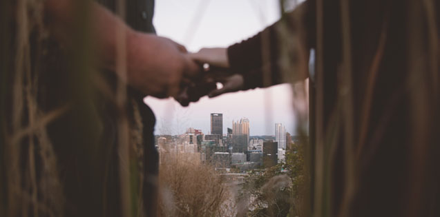 couple holding hands with city in the background