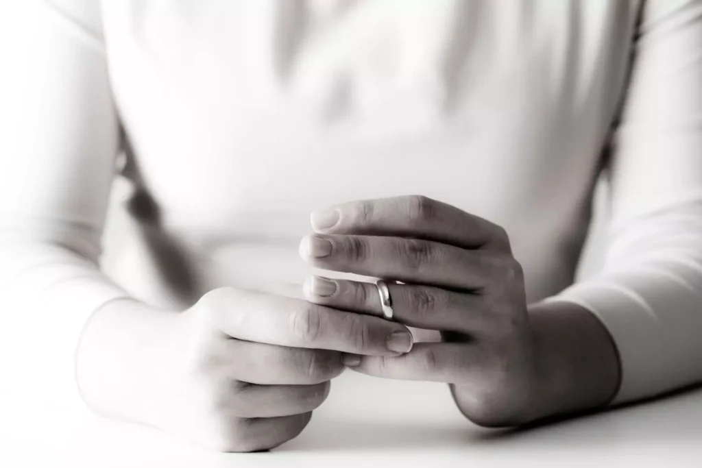 A woman pulling off her wedding ring - divorce