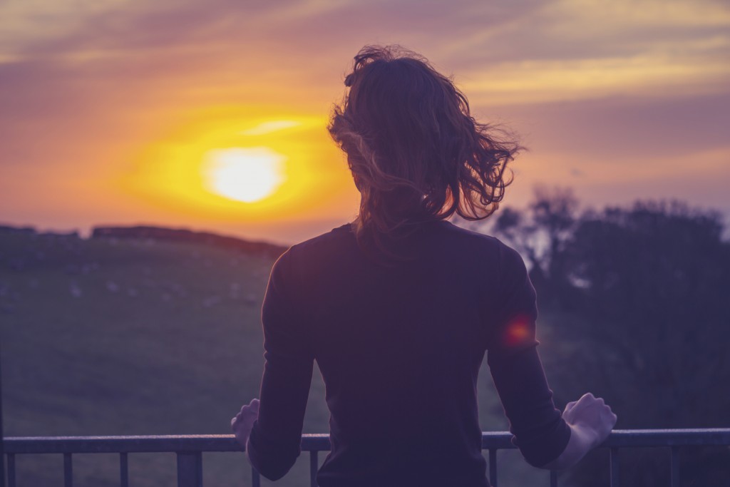 Young adult woman watching hte sunset