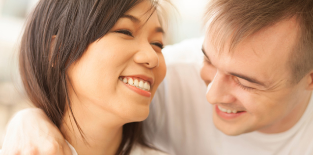 White man and Asian woman smiling together