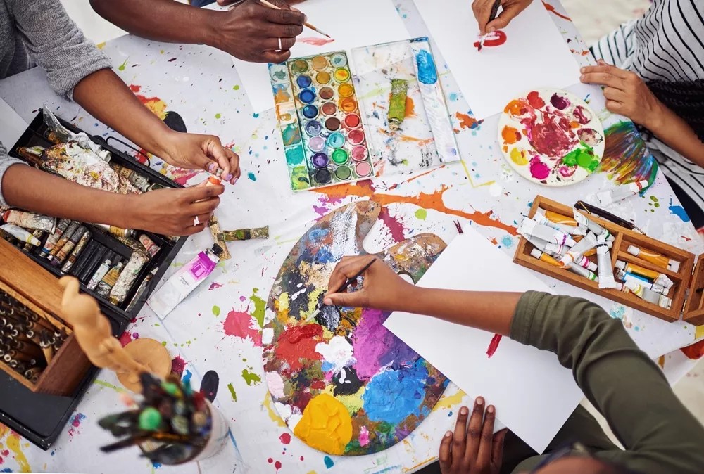 A group painting with bright colors expressing their creativity