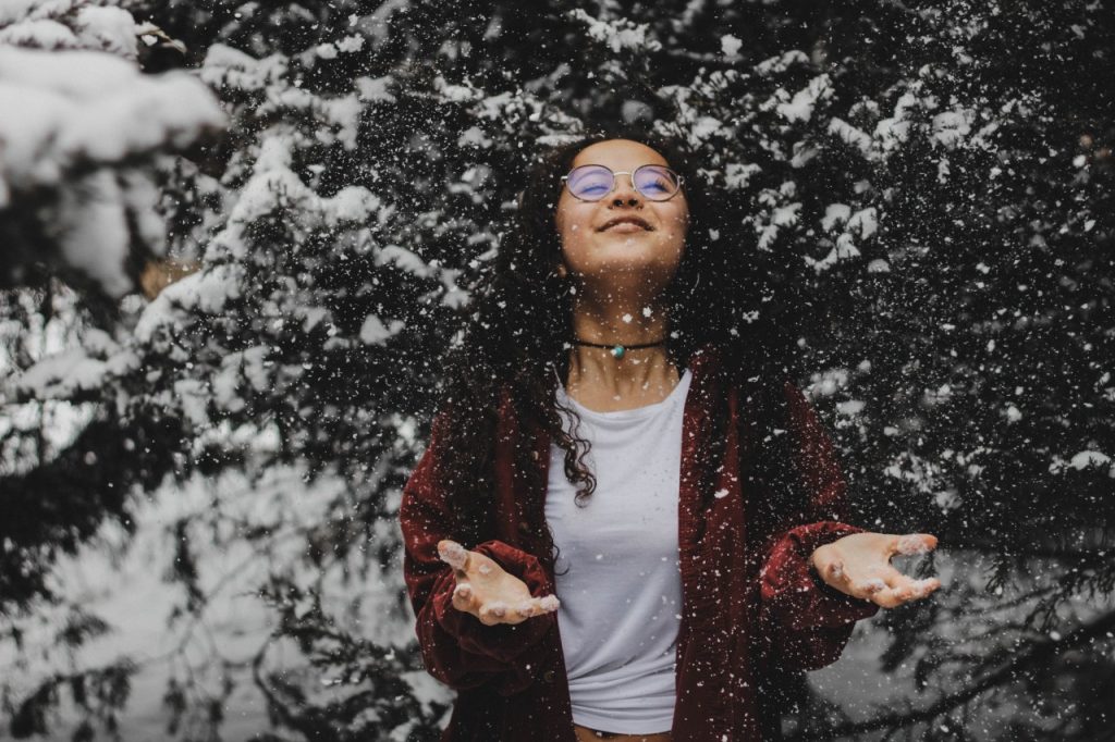 Woman smiling enjoying the snow fall