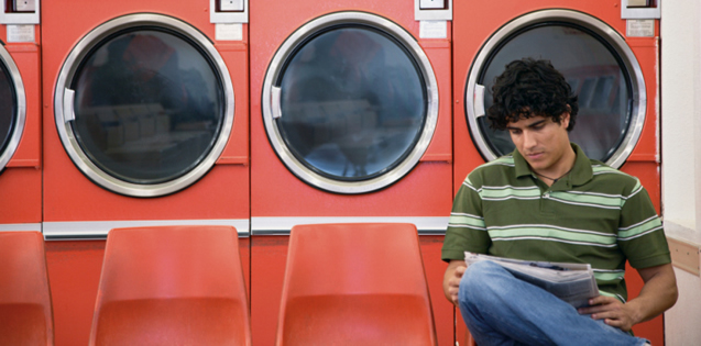 man sitting at laundromat