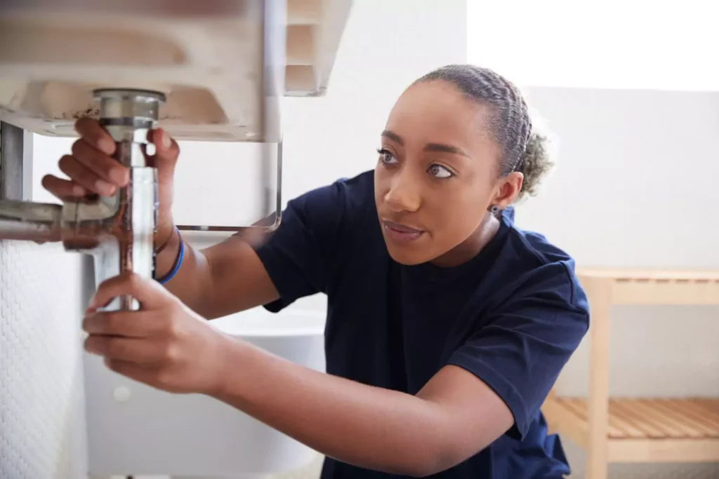 a woman exerting her independence and fixing her sink
