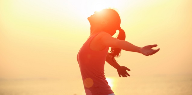 cheering woman open arms at sunrise beach