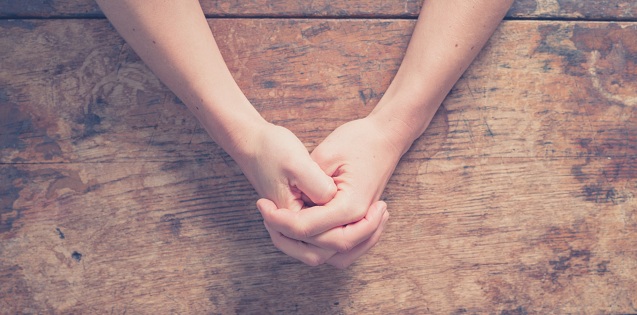 folded hands on table