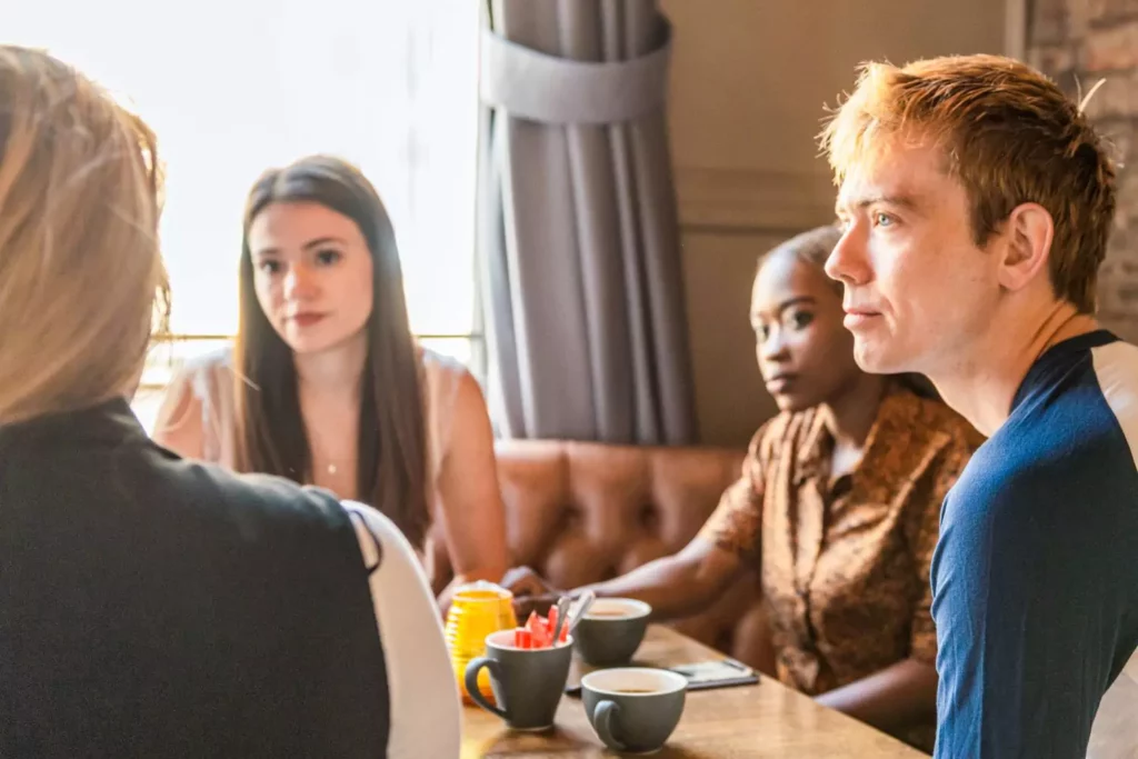 friends around a table listening, pursuing evangelism