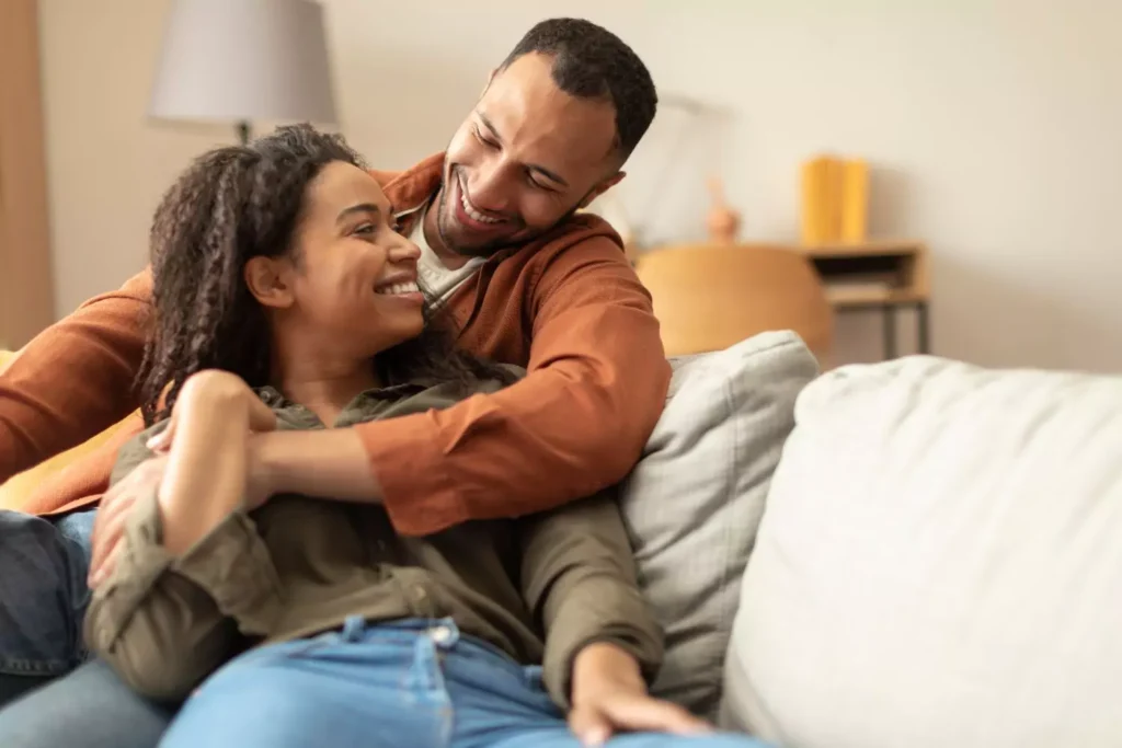 a married couple cuddling on the couch; marriage is fun