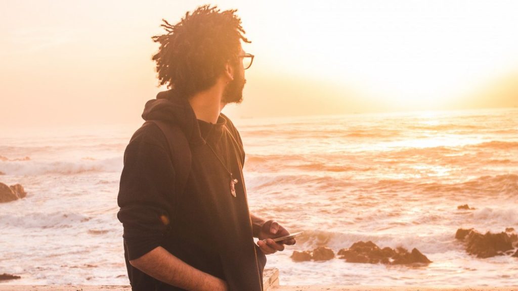 man walking on beach during sunset