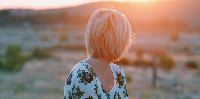 Single young adult woman looking into desert sunset