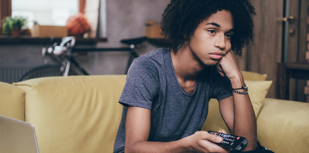 bored young adult man watching tv