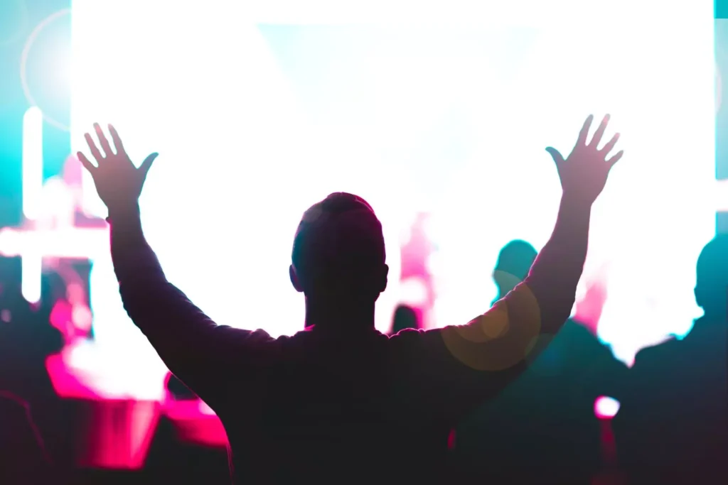 A man at a concert lifting his hands in worship