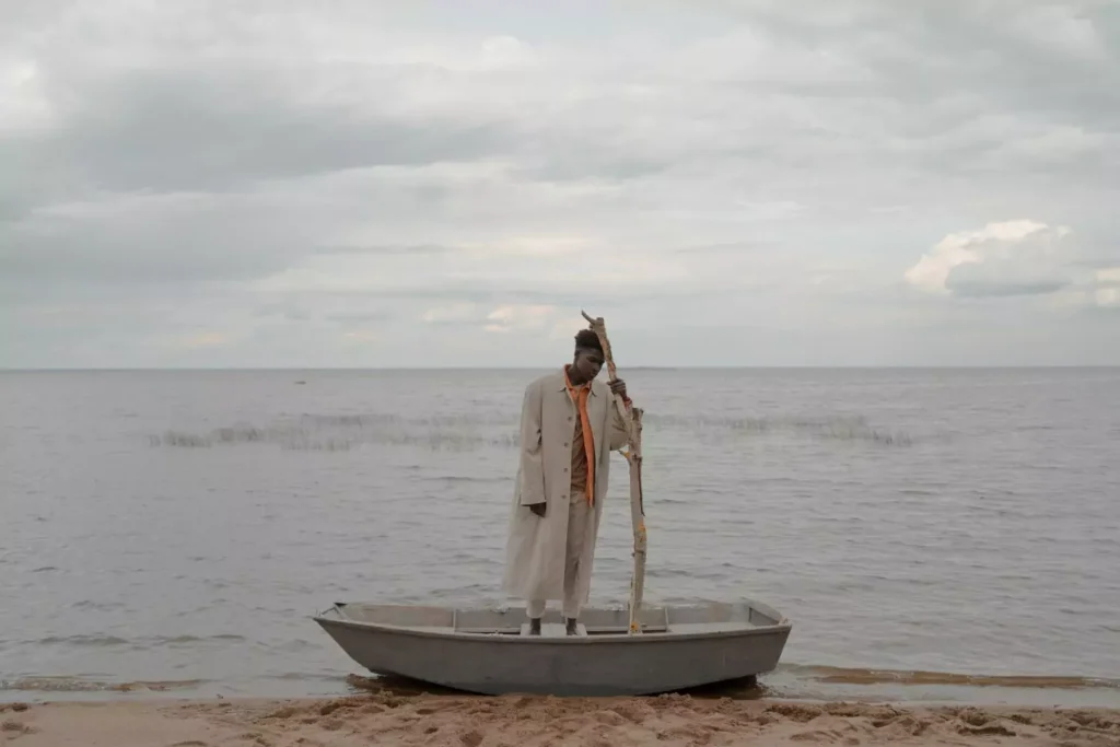 a man standing in a boat, doubting he will catch anything