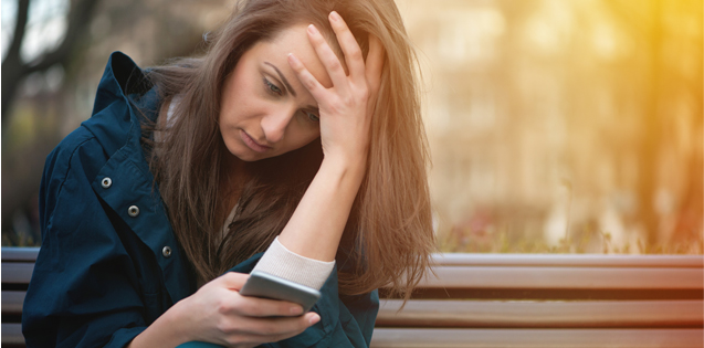 Woman looking dejectedly at phone