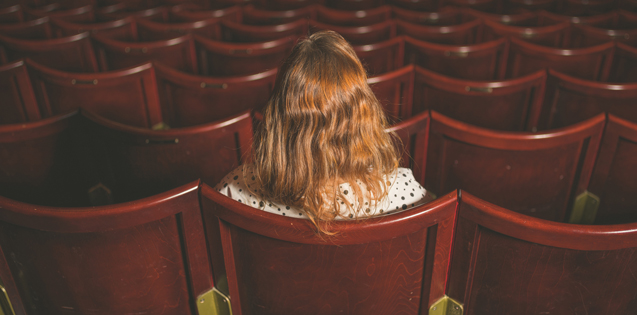 Woman sitting alone in a theater