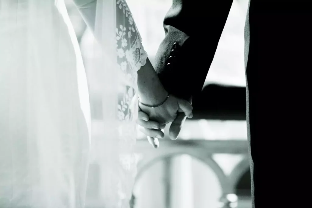 a bride and groom holding hands, ready for marriage