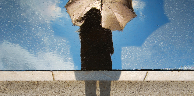woman standing over a puddle in the rain