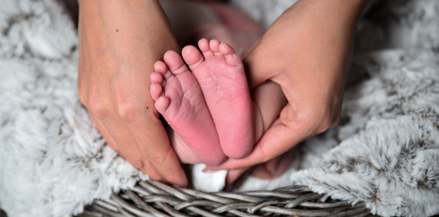 A woman holding a baby's feet