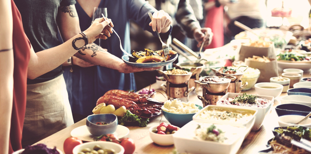 People gathered around a table of food